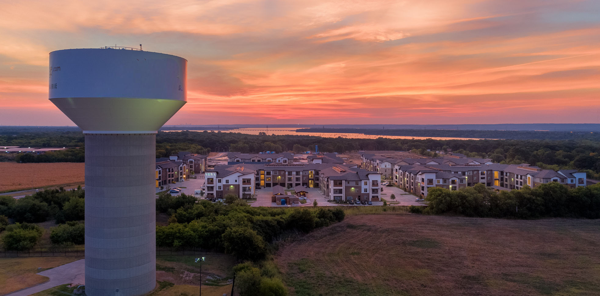Aerial campus‑level view featuring a water‑tower landmark, surrounding buildings, and natural landscape.